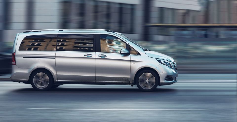 A silver minivan is driving quickly on an urban street with motion blur indicating speed. A silver minivan is driving quickly on an urban street with motion blur indicating speed.